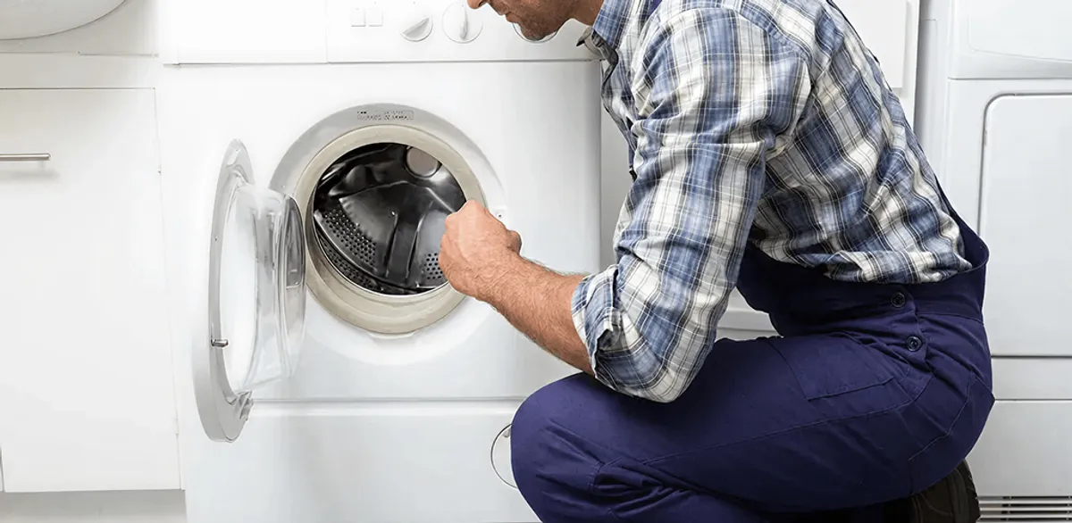 Handyman inspecting a dryer drum and internal parts for repair in Boston, MA