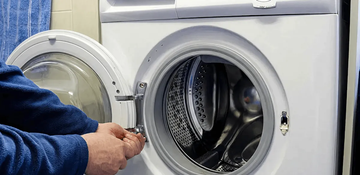 Washing machine repair handyman checking a front-load washer door and latch in Boston, MA