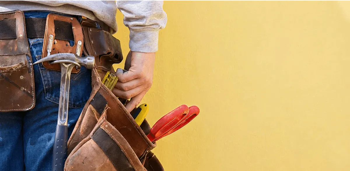 Handyman with tool belt ready for home repairs and maintenance in Boston, MA