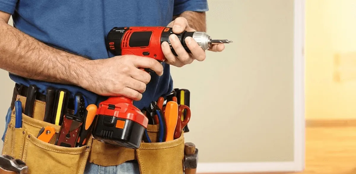 Handyman holding a power drill for home repairs and installations in Boston, MA